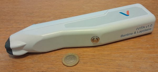 The fully assembled rVITA variant produced during this award, shown with a coin for scale. The button is used to start the imaging sequence which is performed by the integrated device optics and controlled through electronics mounted on a custom printed circuit board inside the device. A microUSB port at the back connects the device to a computer for viewing images and configuring sequences.