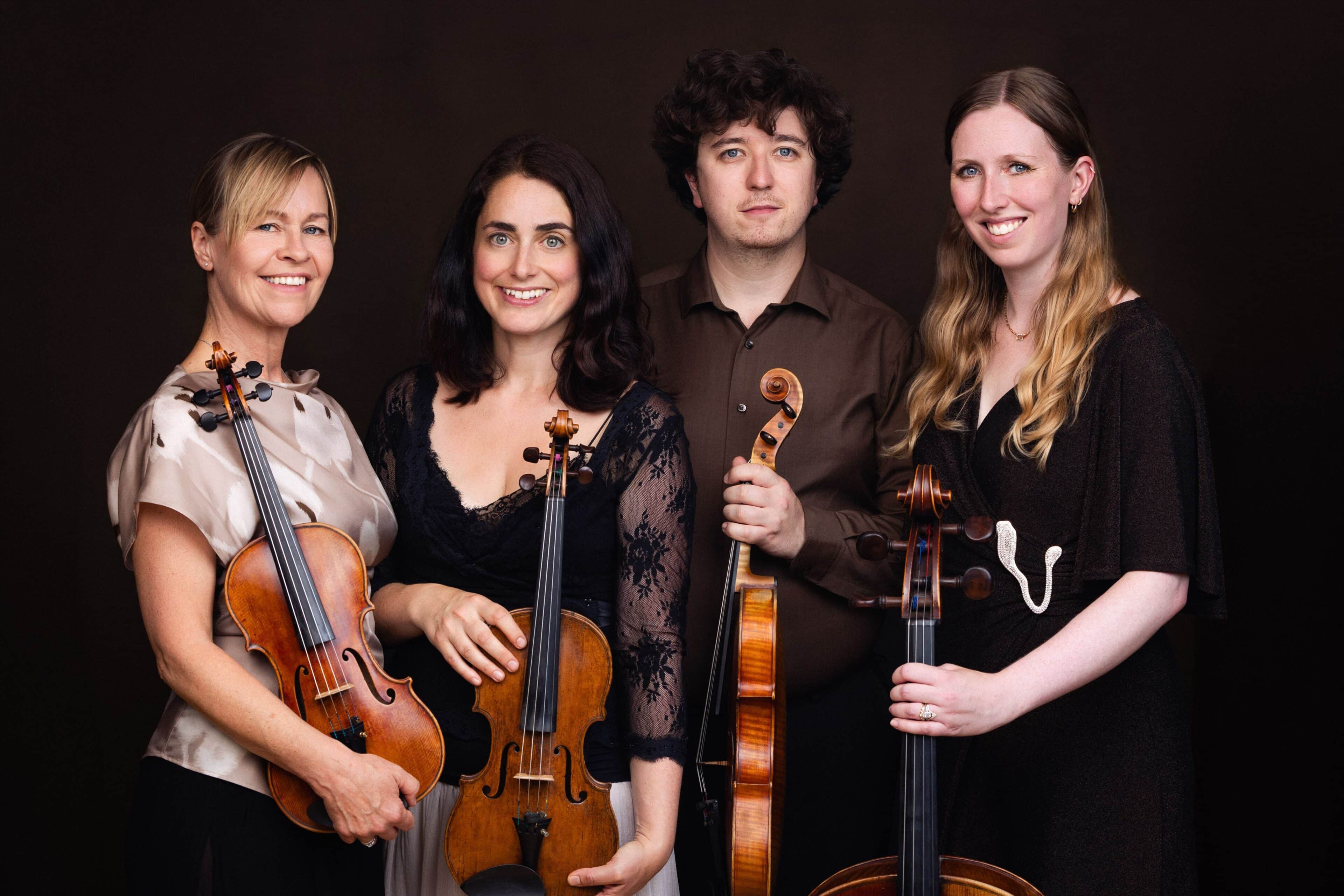 The four members of the group holding their instruments