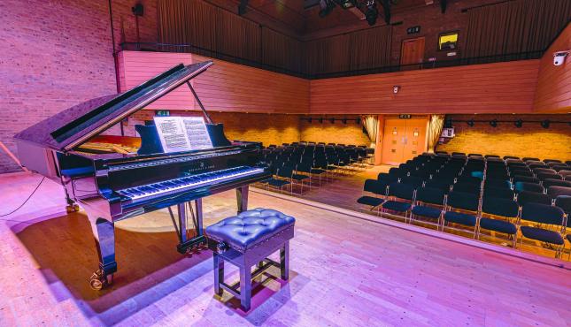 photo of piano on jdp stage under lights