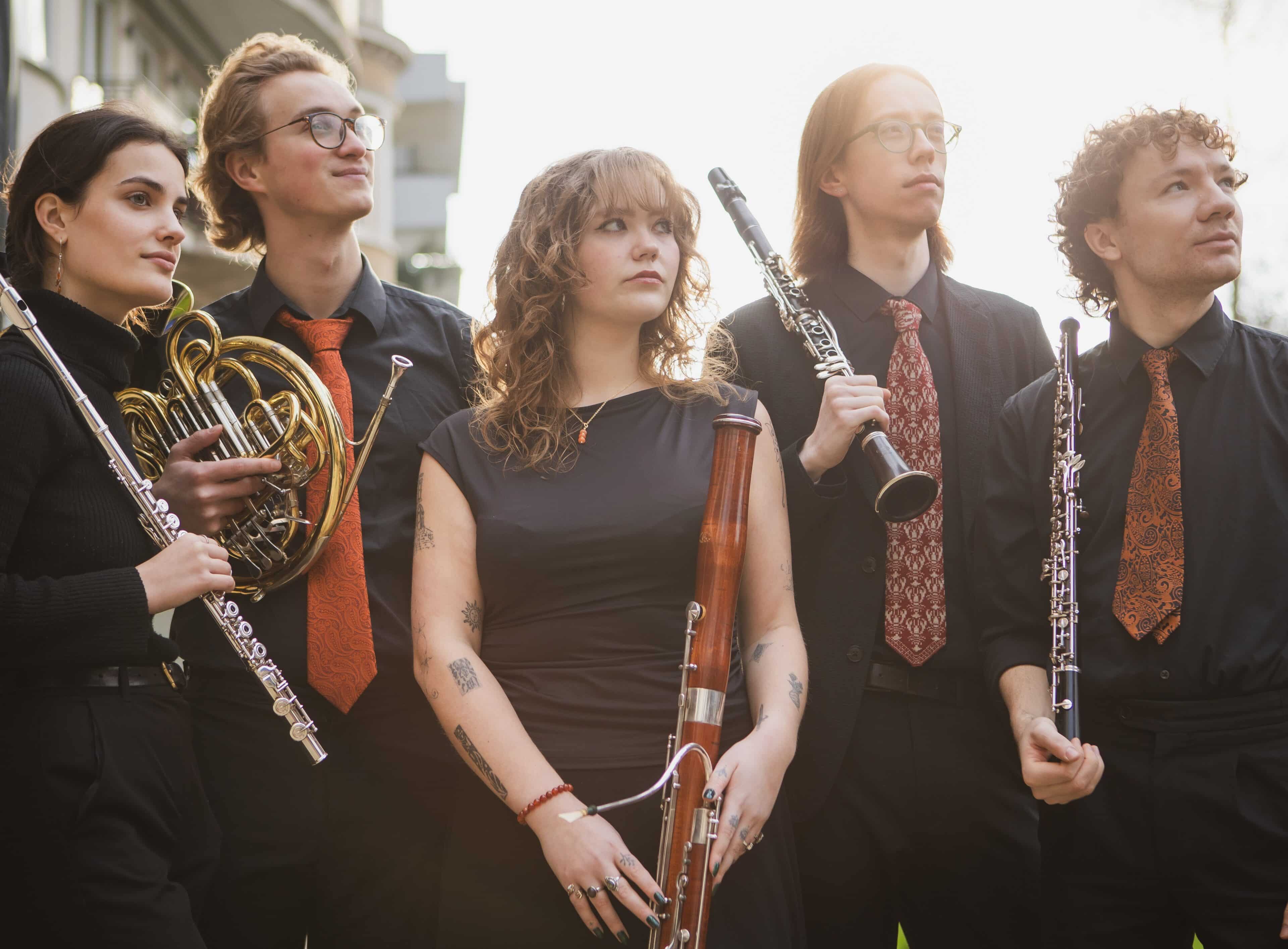 photo of the 5 members of the quintet holding instruments and all looking to their left
