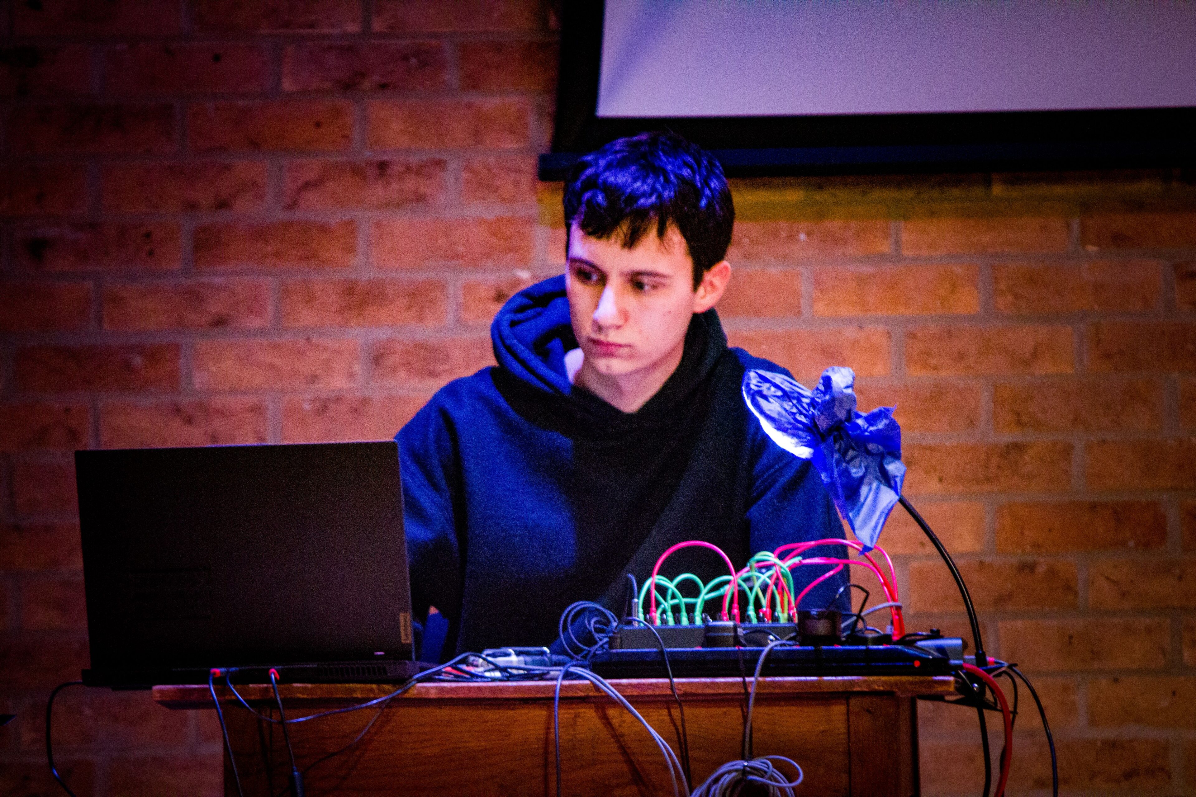 Photo of student in front of a laptop and sound desk on the JdP stage